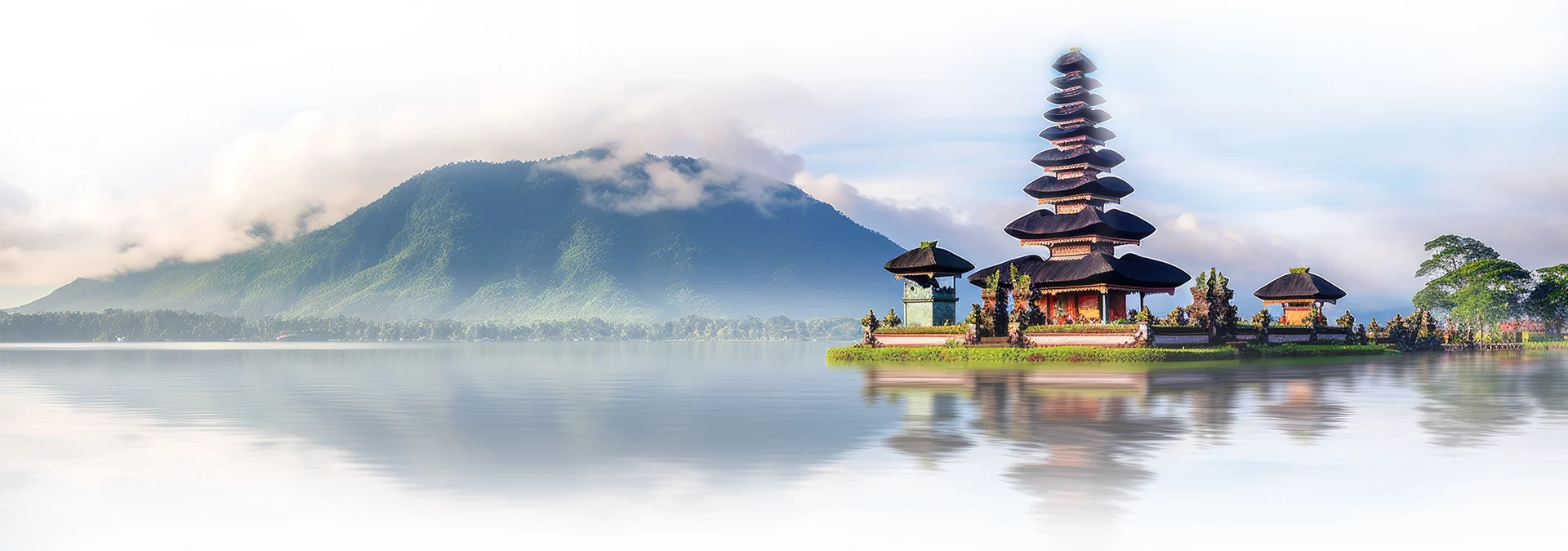 Templo junto al lago con montañas al fondo